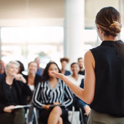 Shot of a young businesswoman delivering a speech during a conference